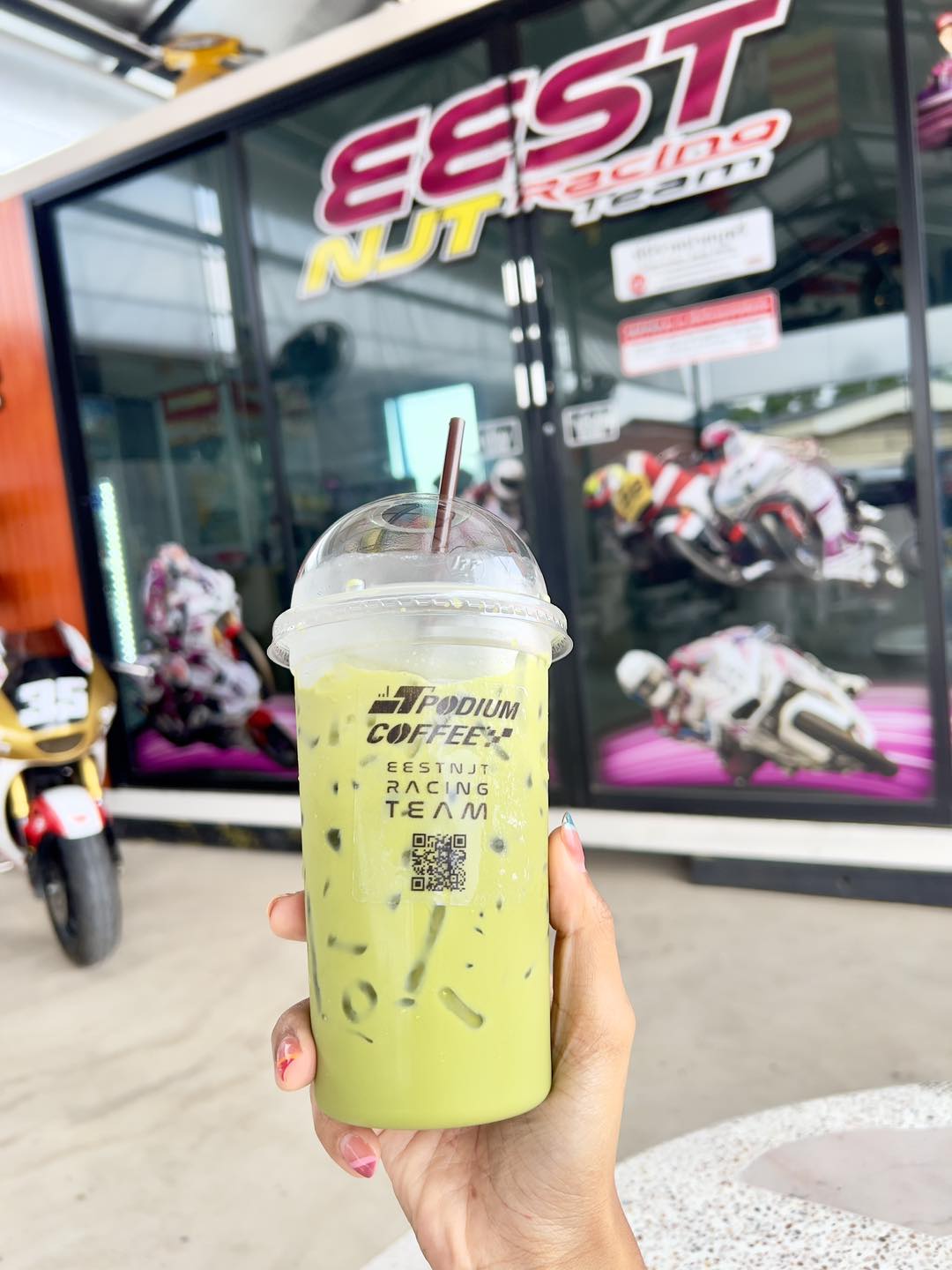 เครื่องดื่มเย็นแก้วจริงจากร้านในสนาม ถ่ายหน้าอาคาร EEST NJT Racing Team / A real iced drink from the on-site café, shot outside the EEST NJT Racing Team building