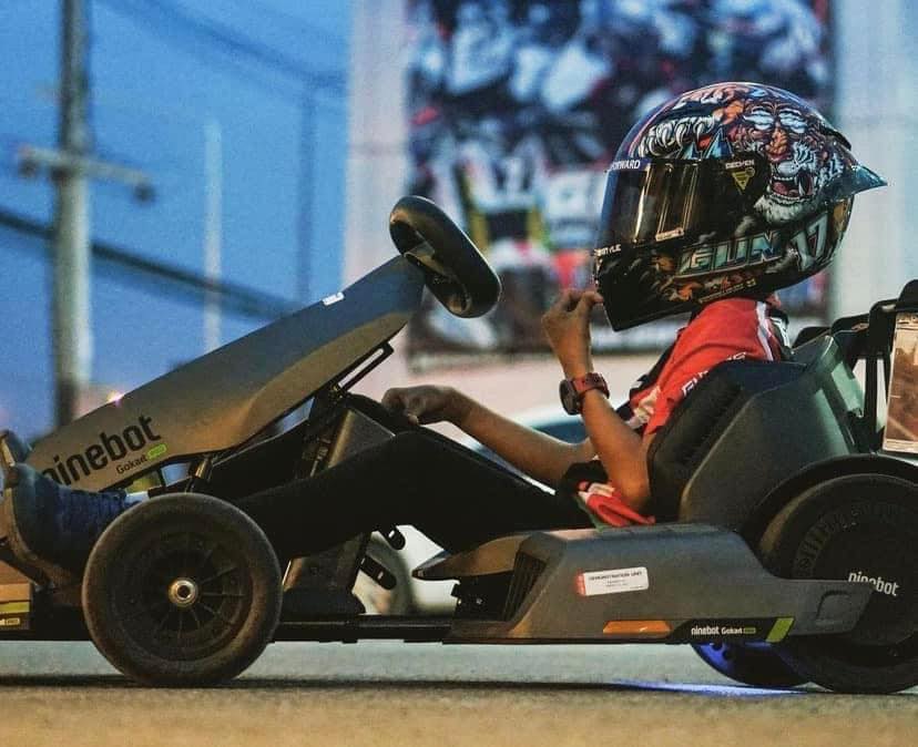 คนขับสวมหมวกกันน็อคเต็มใบบนโกคาร์ทไฟฟ้า Ninebot ที่สนาม EEST NJT / A driver in a full-face helmet on a Ninebot electric go-kart at EEST NJT