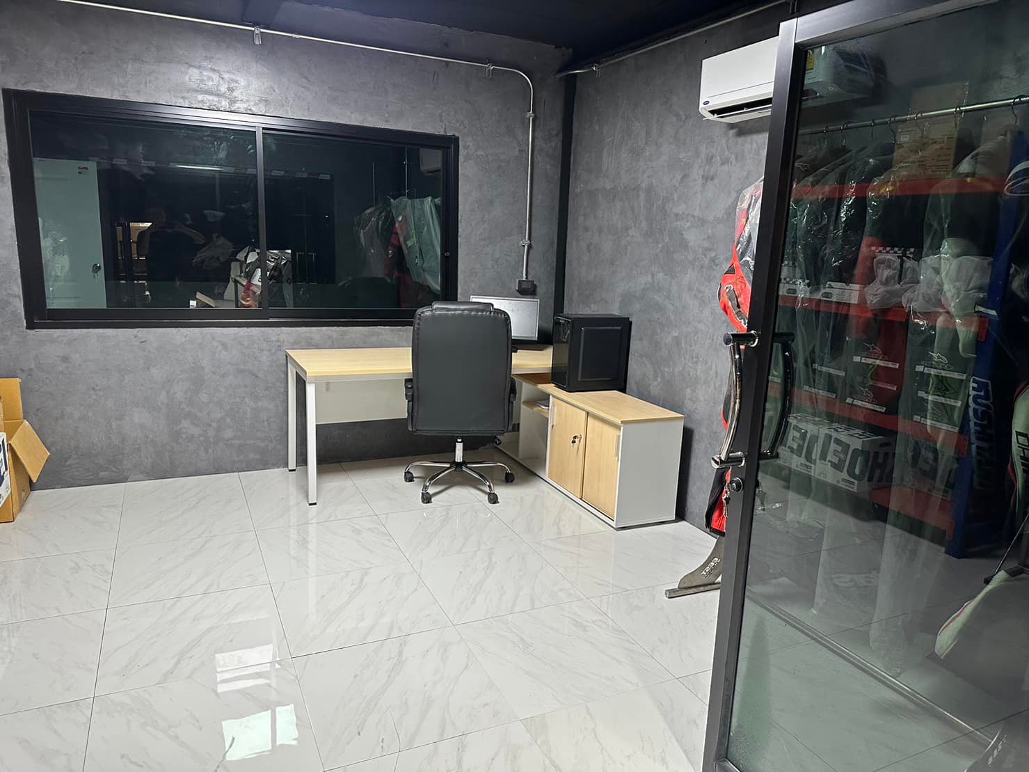 ห้องอุปกรณ์และบรีฟฟิ่ง มีชุดแข่งและอุปกรณ์แขวนเรียงไว้ / The gear and briefing room, with race suits and equipment racked ready