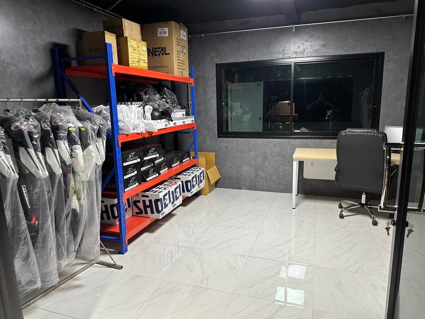 ห้องเก็บอุปกรณ์ความปลอดภัย ชุดแข่ง หมวกกันน็อค และรองเท้าจัดเรียงบนชั้น / The safety equipment room, with race suits, helmets and boots racked on shelves