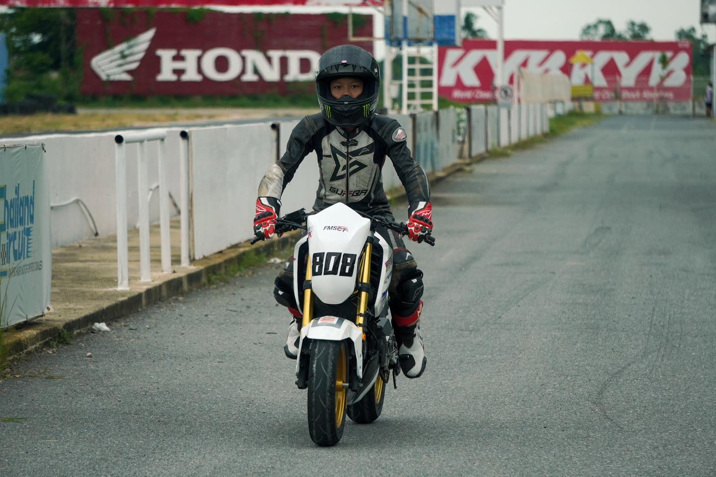 ป้ายแบรนด์พันธมิตรริมสนามในสุดสัปดาห์การแข่งขัน — Honda และ KYB บนกำแพงสนาม / Partner brand signage trackside on a race weekend — Honda and KYB on the circuit walls