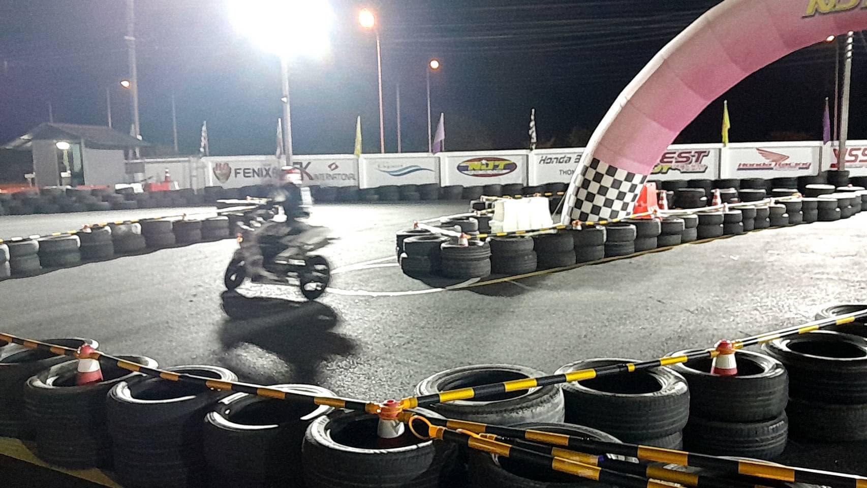 The mini circuit at night lit by floodlights with a rider on track