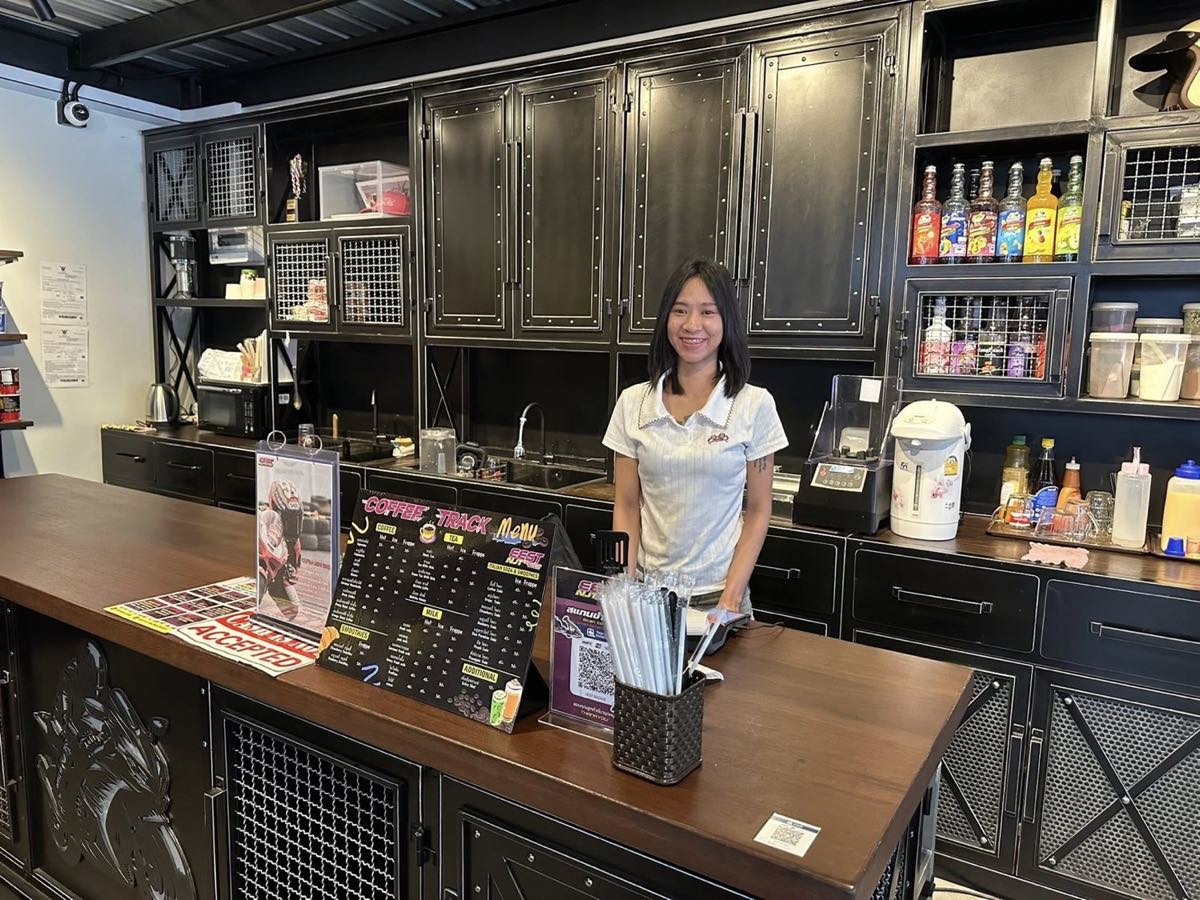 A smiling barista behind the Coffee&nbsp;Track counter