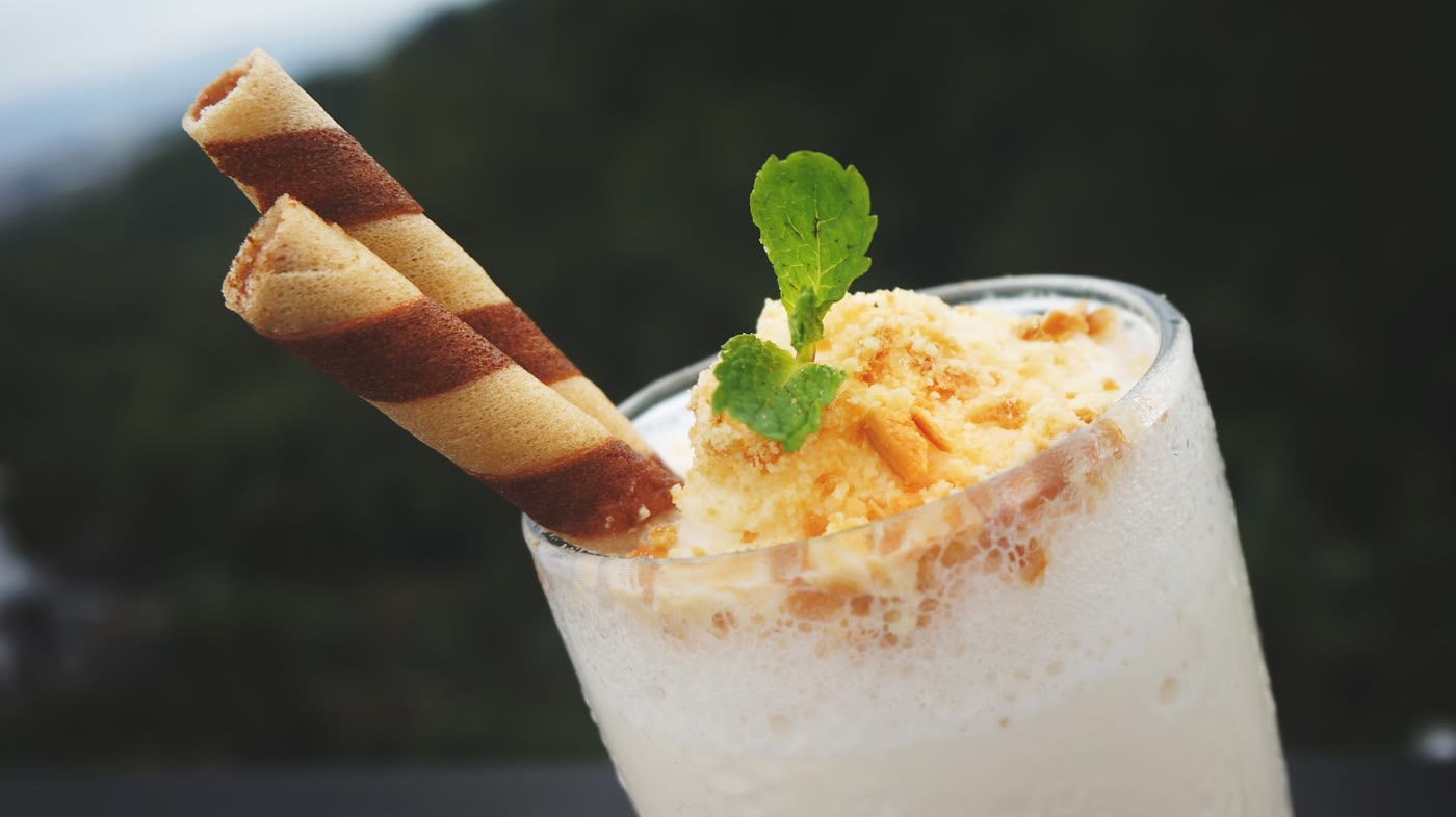 เครื่องดื่มนมปั่นเนื้อครีม โรยหน้าและตกแต่งด้วยเวเฟอร์ (ภาพประกอบ) / A creamy blended milk frappe with crumble topping and wafer sticks (illustrative stock image)