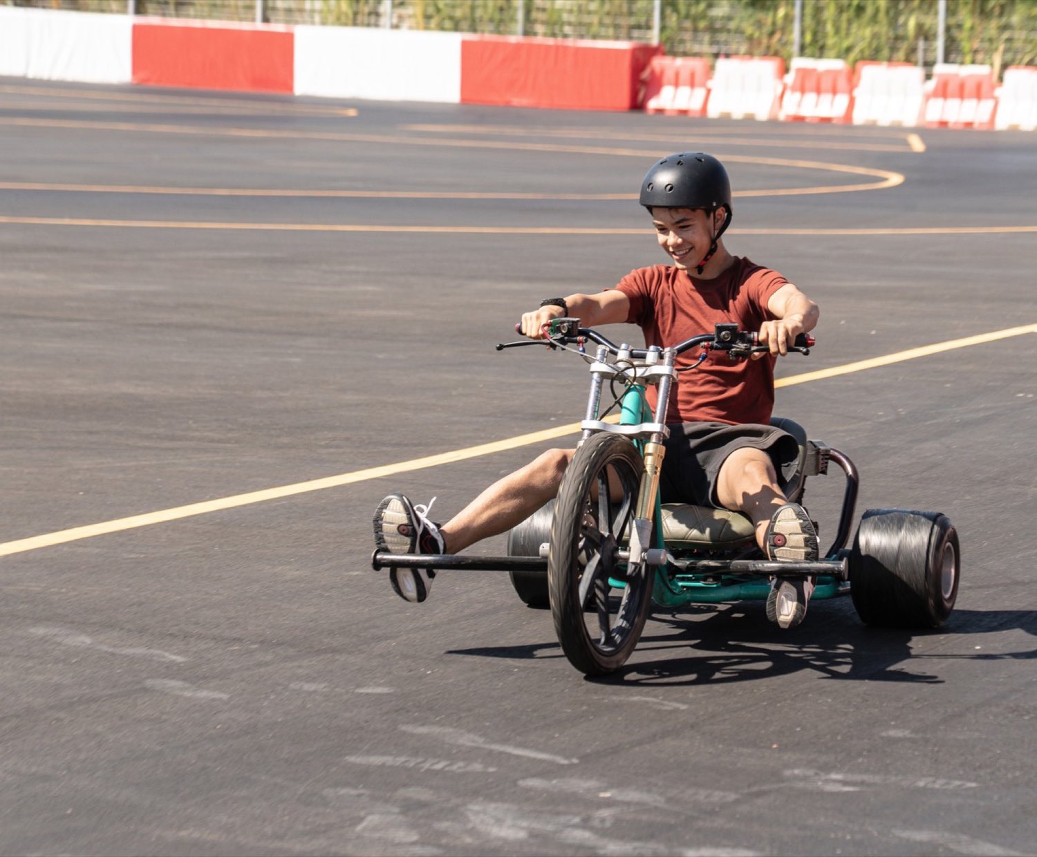 Teenager riding a three-wheeled drift trike on the track