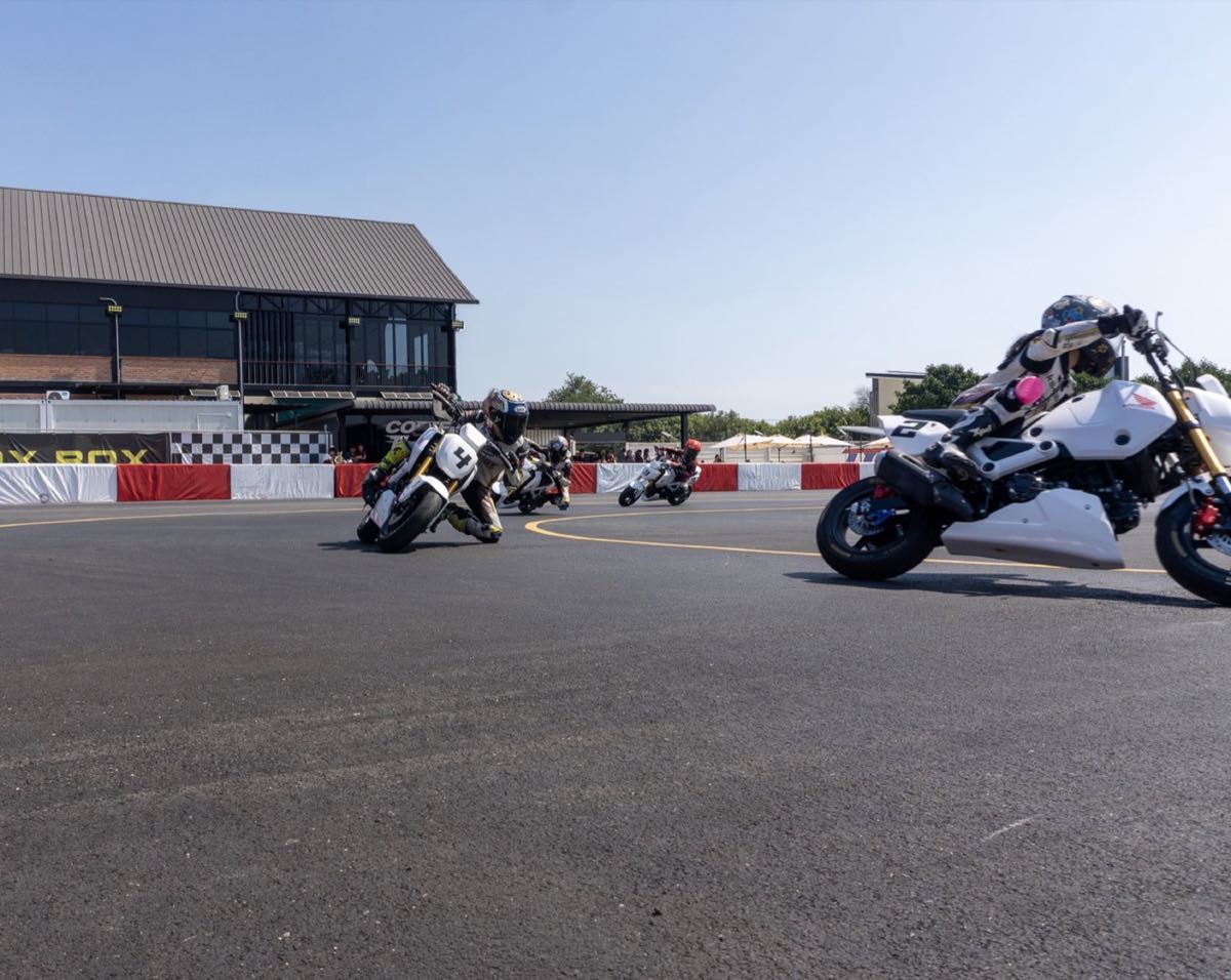 Riders cornering on Honda Grom bikes at the circuit